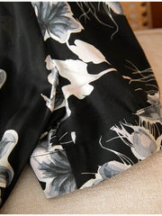 Close-up of the Chic Floral One - Piece Mulberry Silk Dress showcasing floral details on a black background.