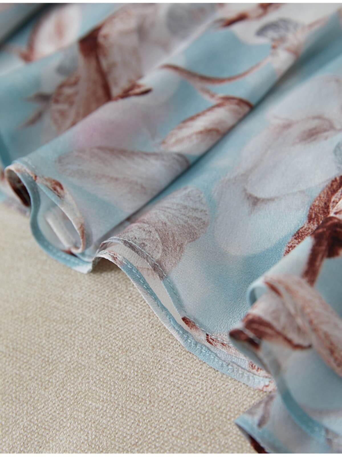 Close-up view of fabric showcasing the delicate floral pattern of the Blue Floral Mulberry Silk Dress.