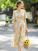 French Floral Mulberry Silk Maxi Dress featuring a woman outdoors in a cream yellow floral design, carrying a sunflowers bag.