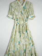 Resort Style Mulberry Silk Dress in light green with blue accents, featuring a wrap design and tie waist.