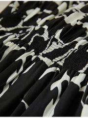 Floral Mulberry Silk Dress detail showcasing the elegant black and white floral pattern and smocked fabric texture.