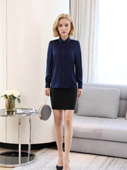 Women's Refined Minimalist Silk Blouse styled elegantly with a black skirt in a modern interior setting.