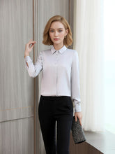 Woman wearing a Women's Refined Minimalist Silk Blouse with buttons, paired with black trousers.