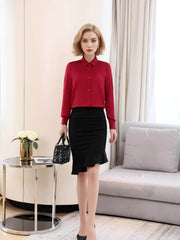 Woman wearing a red blouse and black skirt in a modern living room, showcasing Women's Refined Minimalist Silk Blouse.