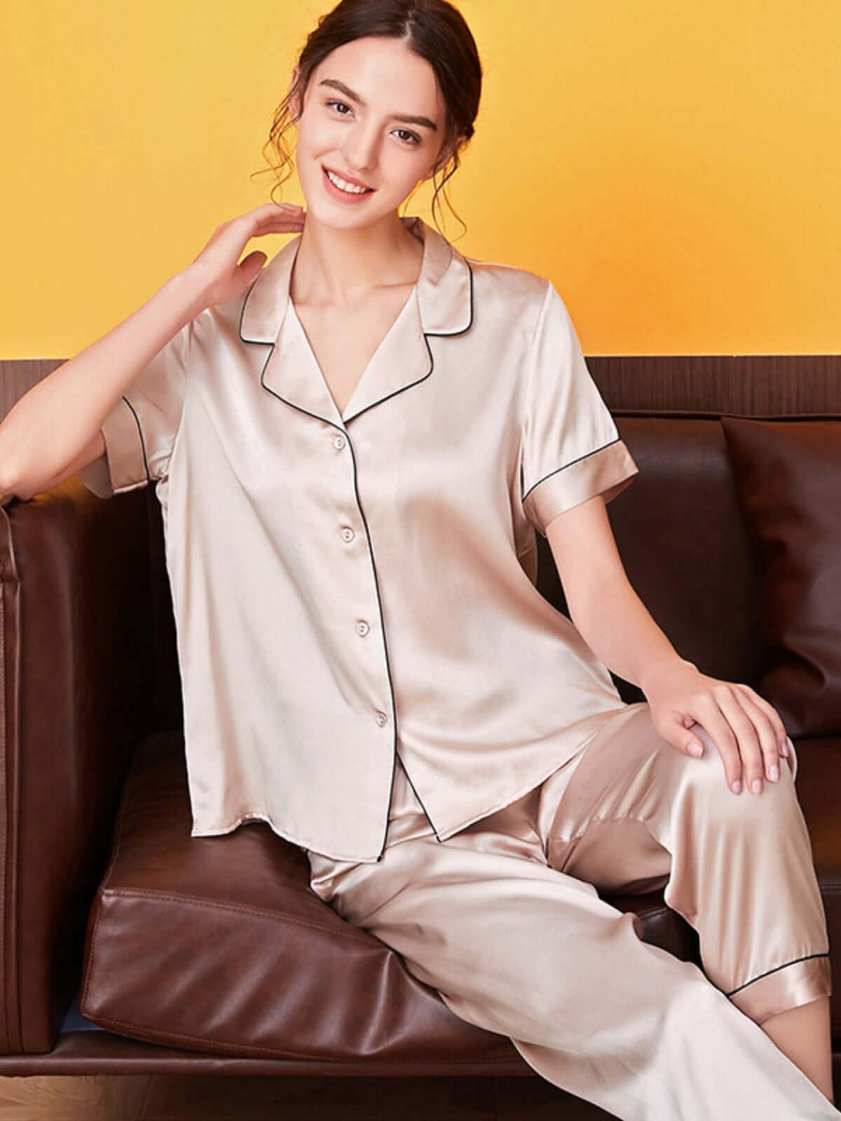 Model wearing Women's Cozy Short - sleeved Pure Silk Pajamas Set sitting on sofa