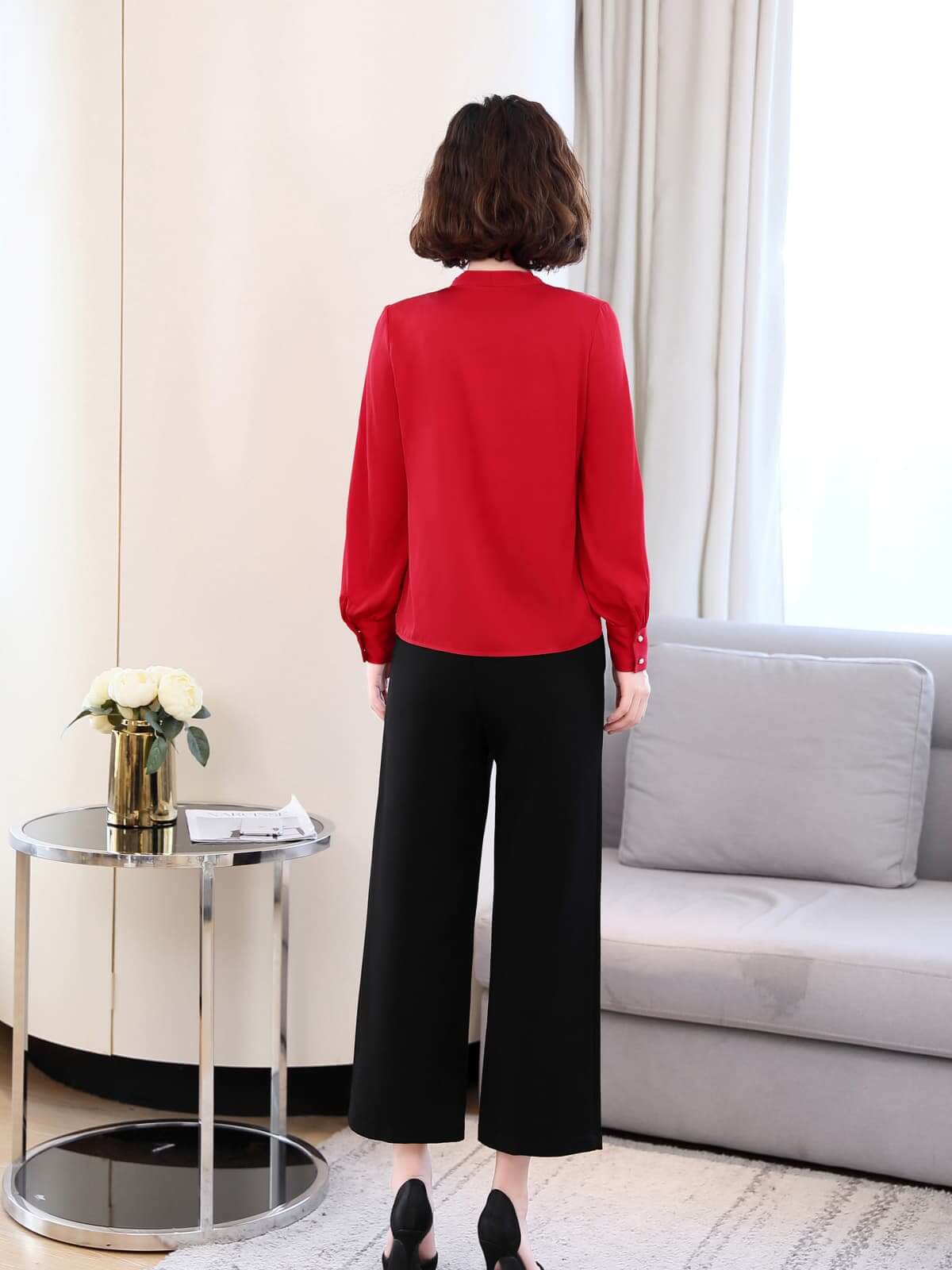 Chic V-neck Silk Blouse in red worn with black pants, stylish for work or weekend outings.