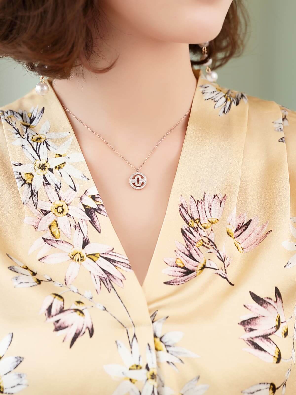 Floral Mulberry Silk Blouse for Women with a delicate floral pattern and a silver necklace worn by a model.