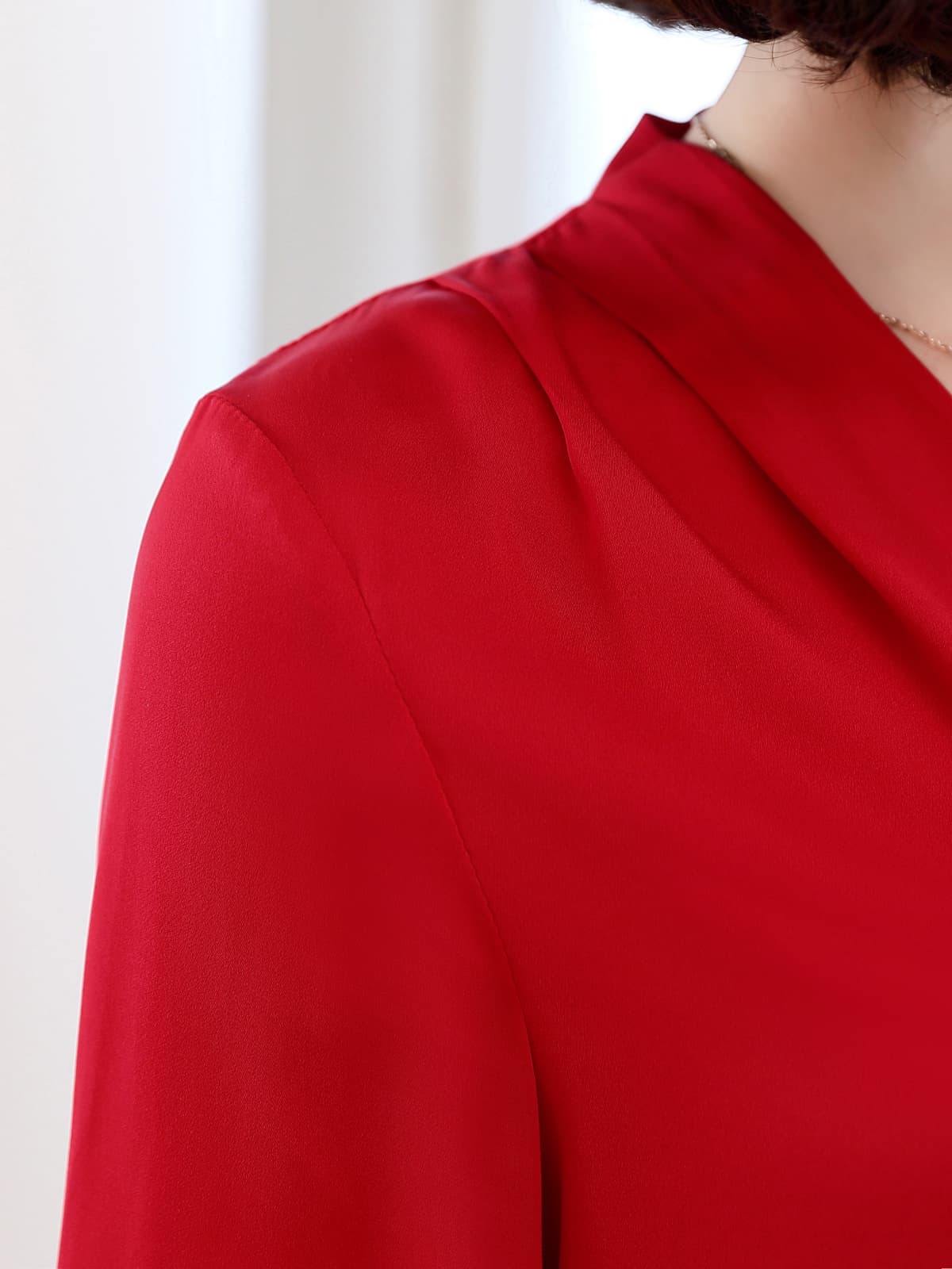 Chic V-neck Silk Blouse in vibrant red showcasing a sleek neckline and elegant fabric texture.