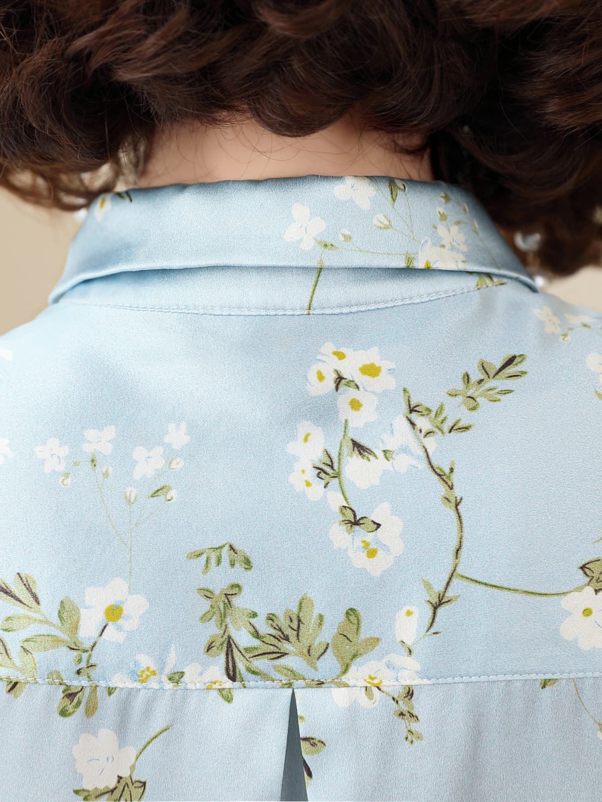 Floral Long Sleeve Mulberry Silk Blouse for Women showcasing delicate floral patterns on a soft blue background.