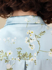 Floral Long Sleeve Mulberry Silk Blouse for Women showcasing delicate floral patterns on a soft blue background.