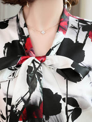 Close-up of the Bow Tie Printed Mulberry Silk Blouse for Women, featuring a floral design and elegant bow tie neckline.