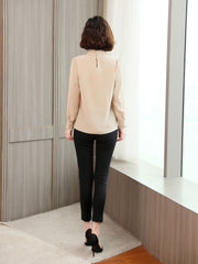 Back view of a woman wearing an Elegant Lace Collar Silk Blouse paired with black trousers.