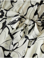 Close-up of the bow detail on a Breathable Mulberry Silk Shirt Dress featuring a floral pattern.