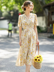 French Floral Mulberry Silk Maxi Dress featuring a woman outdoors in a cream yellow floral design, carrying a sunflowers bag.