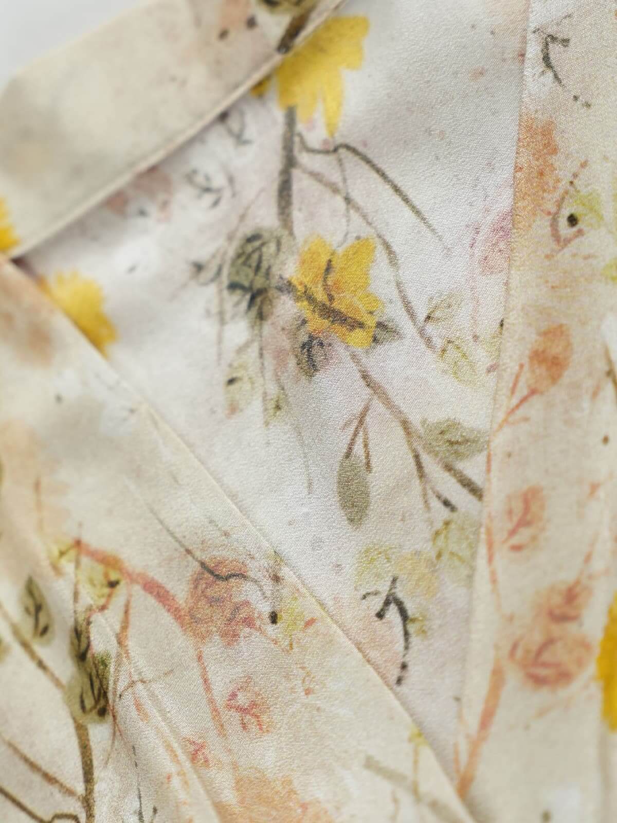 Close-up of the fabric design featuring delicate floral patterns in soft cream yellow on the French Floral Mulberry Silk Maxi Dress.