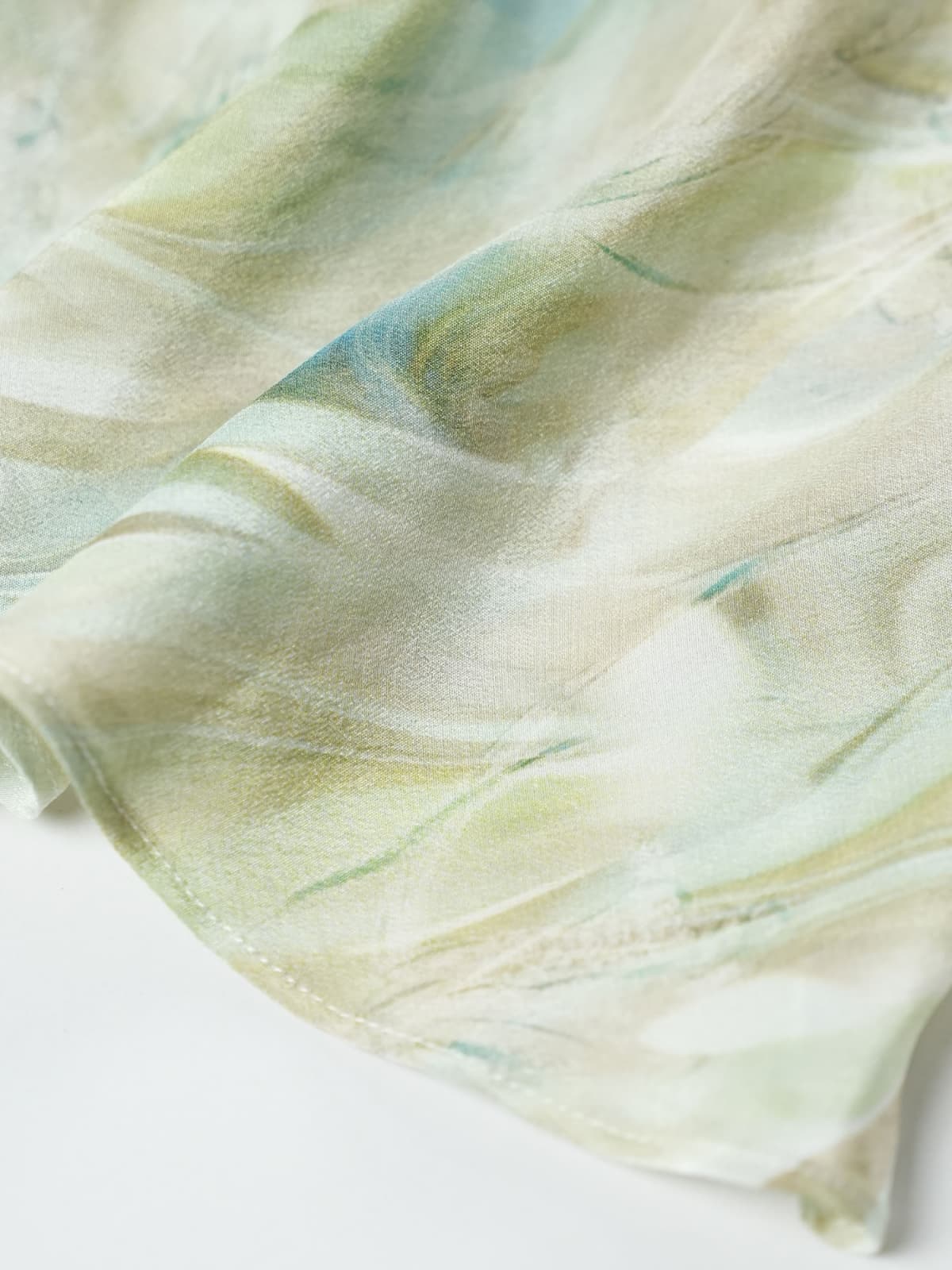 Resort Style Mulberry Silk Dress fabric detail showcasing its soft, breathable texture in a light green color pattern.