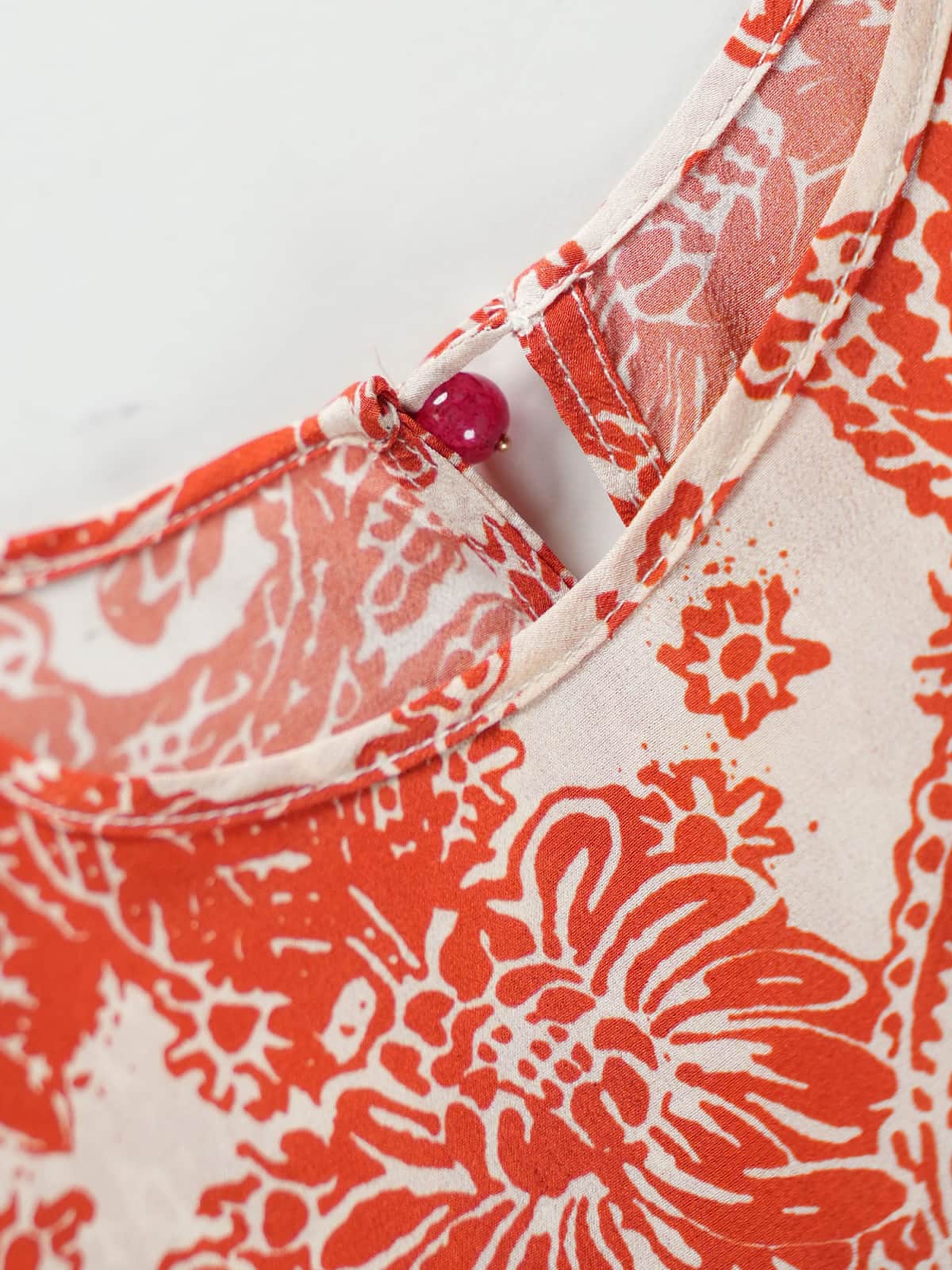 Close-up of the neckline and button detail on the Graceful Mulberry Silk Maxi Dress, showcasing intricate floral patterns.