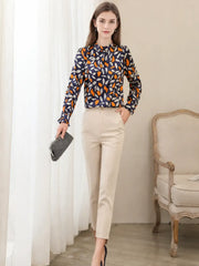 Woman wearing a Vintage Floral Mulberry Silk Blouse, viewed from the back, paired with beige trousers in a stylish setting