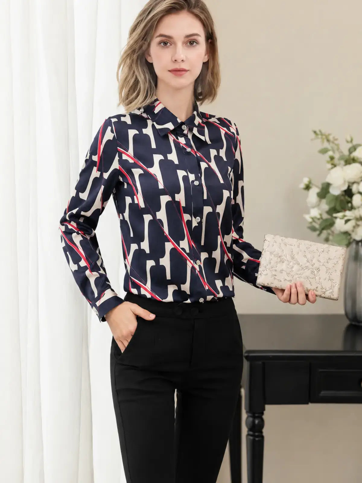 a woman wearing a Luxury Printed Mulberry Silk Blouse paired with black pants in a stylish setting SILKSER